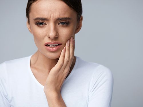 Woman experiencing tooth pain or discomfort.
