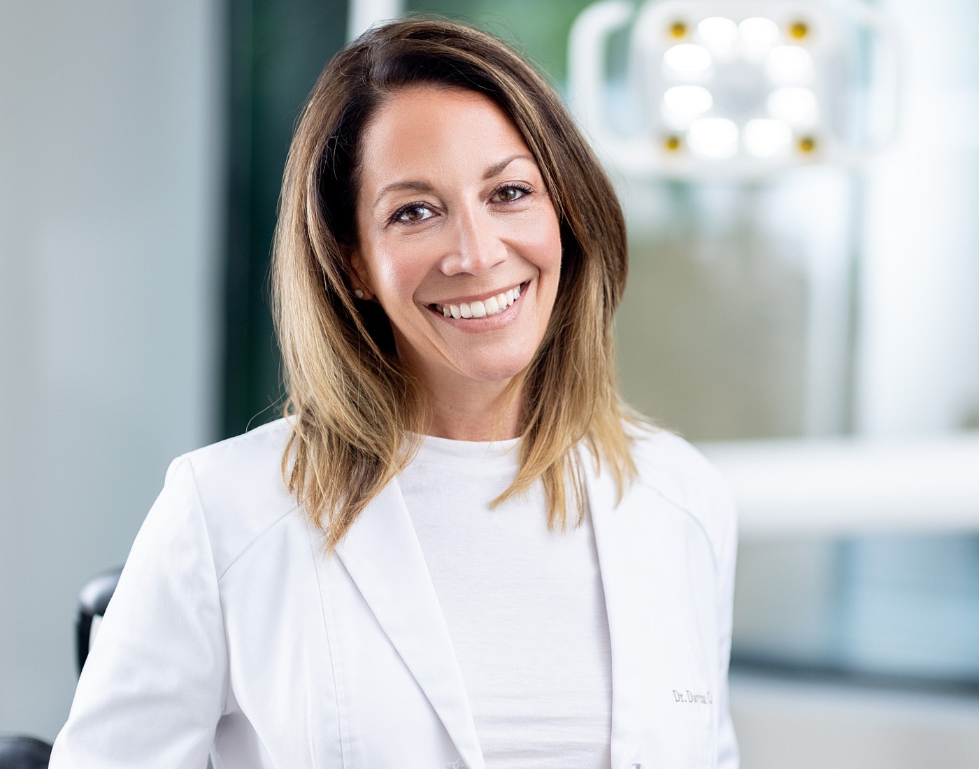 Smiling professional in a dental office setting.